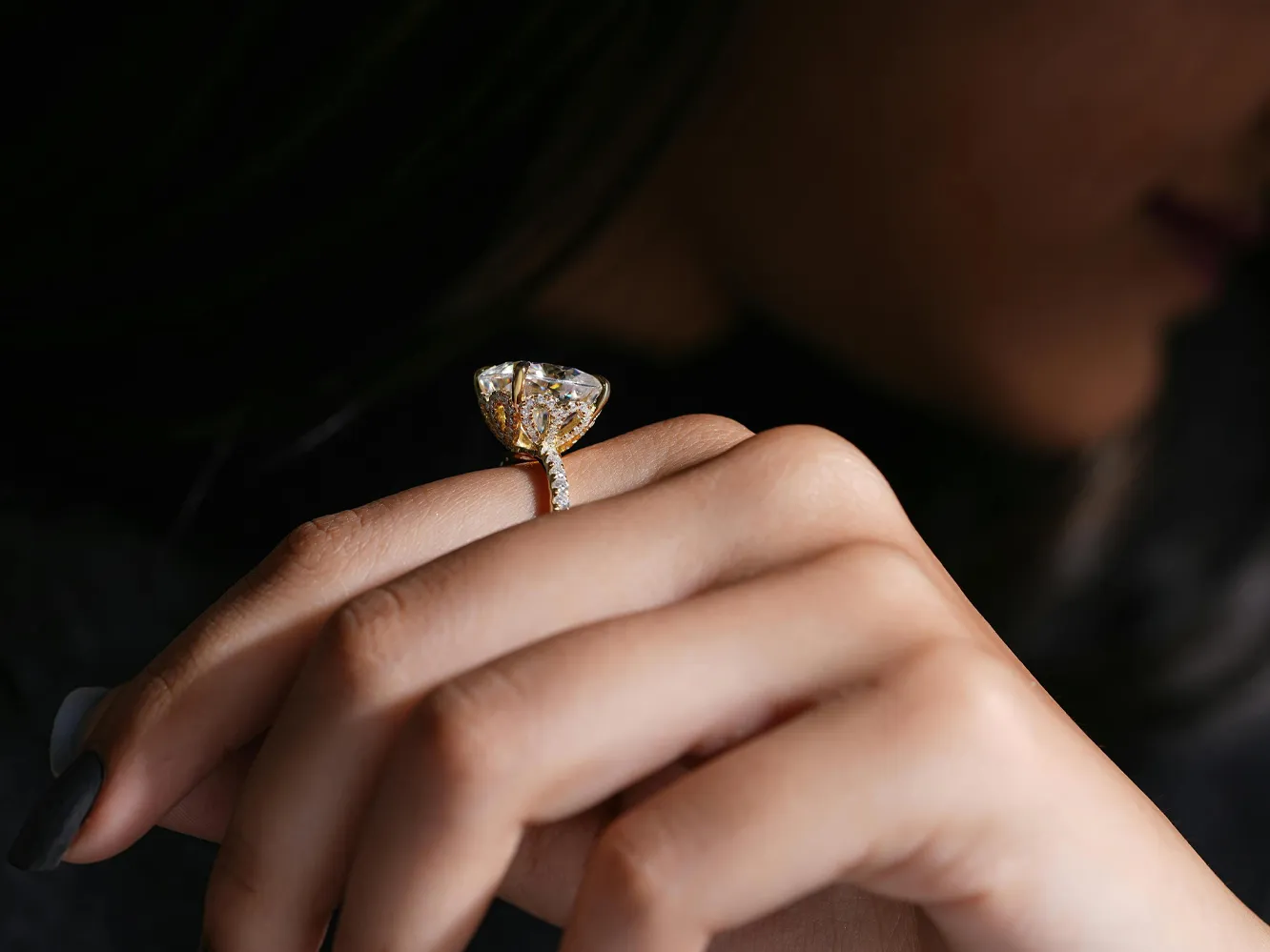 Elegant gold ring with a large diamond, worn on a woman's hand, showcasing fine jewelry craftsmanship. Click to explore Flora Ge