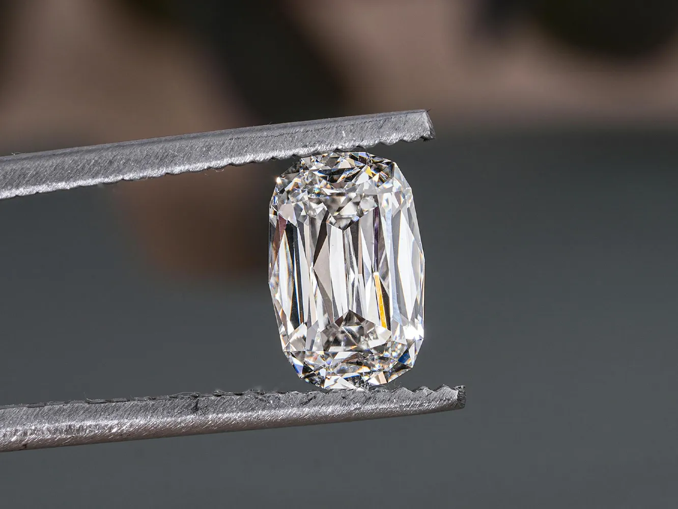 Close-up of a sparkling diamond held by tweezers. Click to explore more at Flora Gems, your jewelry store in Decatur & Champaign