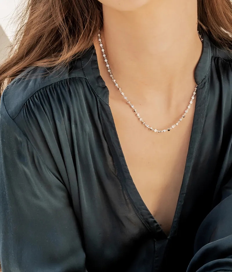 Elegant woman wearing a sparkling necklace, showcasing Allison Kaufman's jewelry.