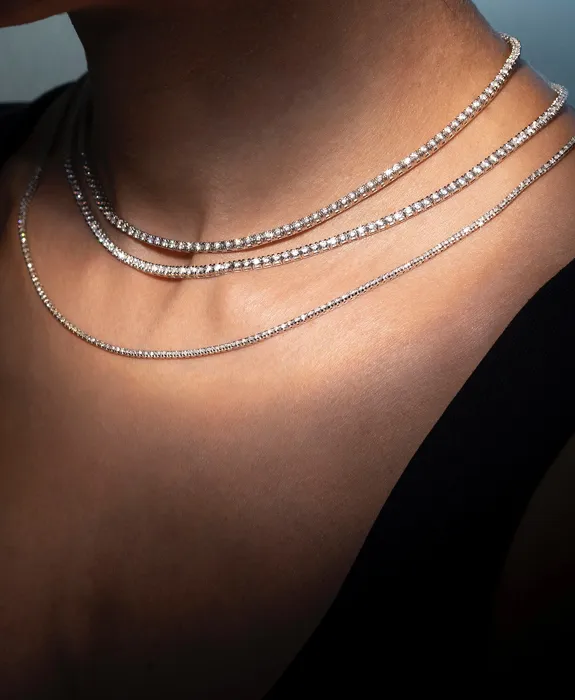 Elegant layered diamond necklaces worn by a model.