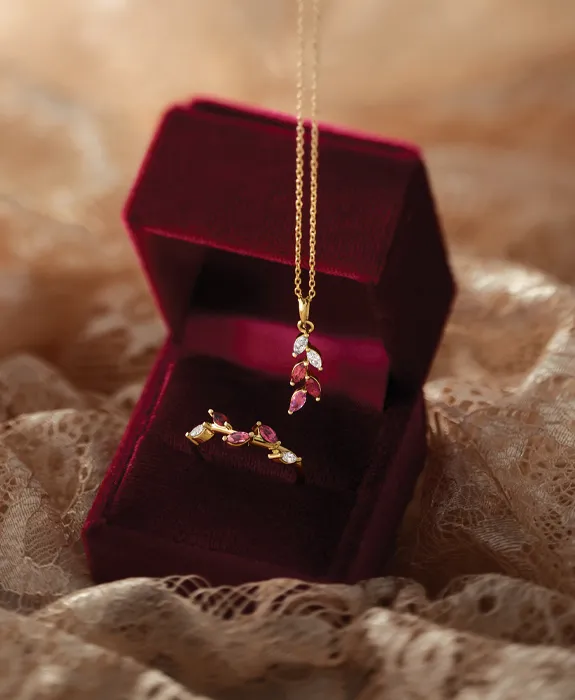 Gold necklace and ring with pink gemstones displayed in a red velvet box. Click to shop fashion jewelry at Futer Bros Jewelers.