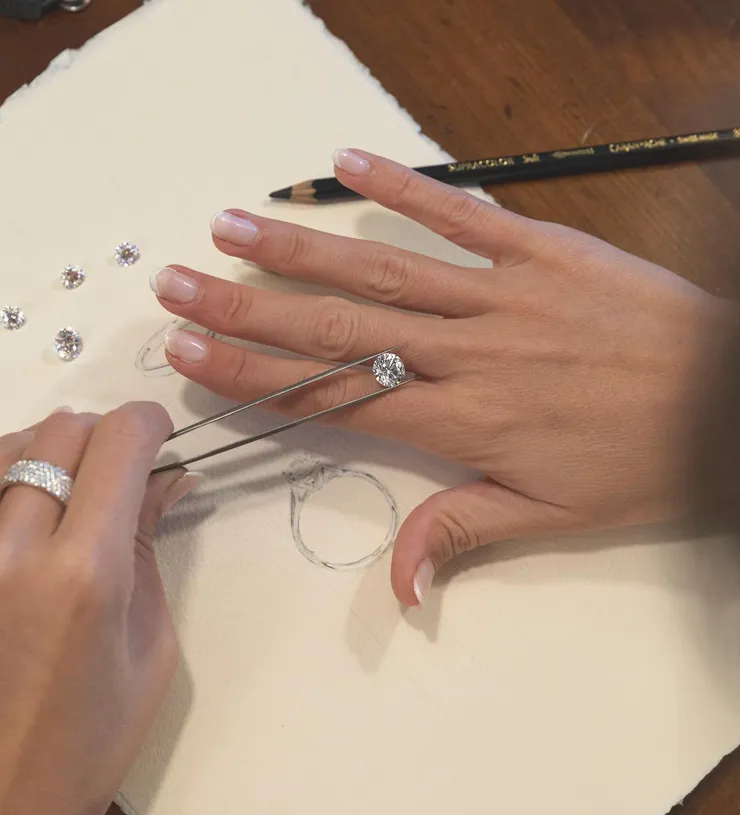Close-up of hands designing a custom ring with diamonds. Click to explore Custom Jewelry Design at Futer Bros Jewelers.