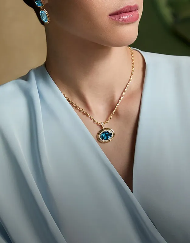 Model wearing blue gemstone necklace and earrings. Shop neckwear at Futer Bros Jewelers.