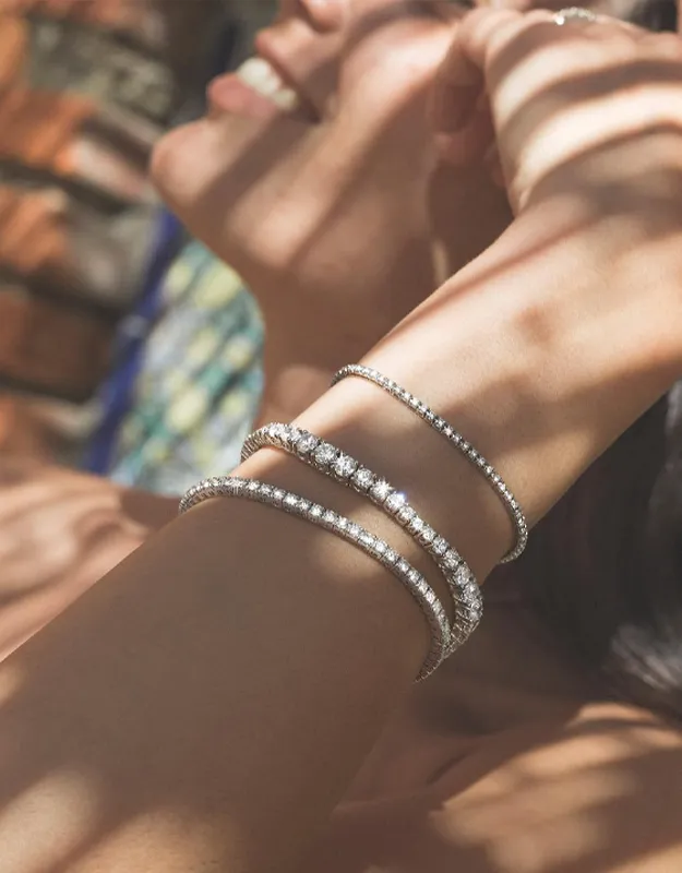 Elegant bracelets with sparkling stones on a woman's wrist. Click to explore more bracelets at Futer Bros Jewelers.