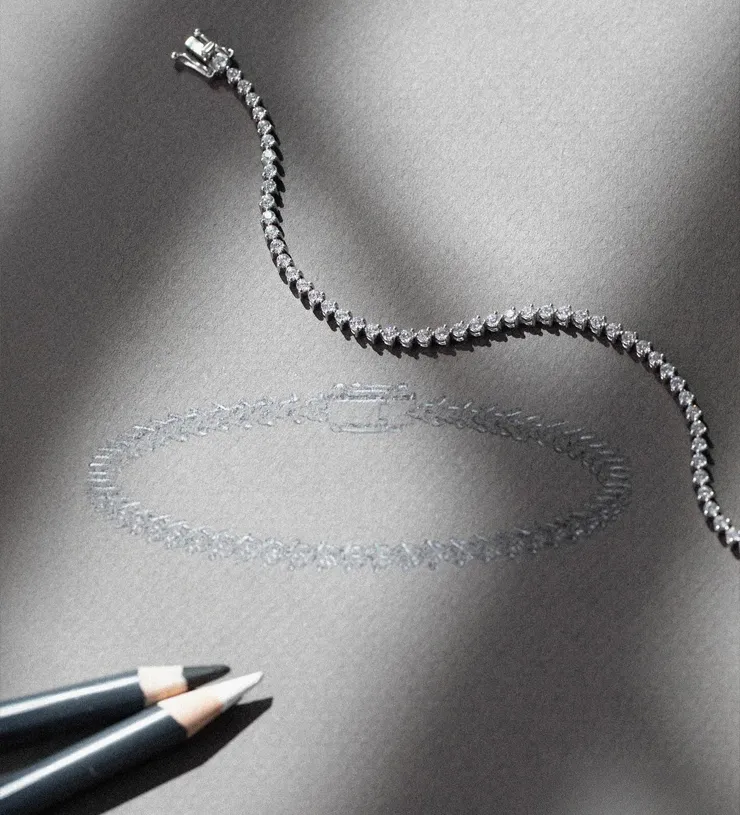 Diamond tennis bracelet on a gray background with colored pencils. Click for Custom Jewelry Design details at Futer Bros Jeweler