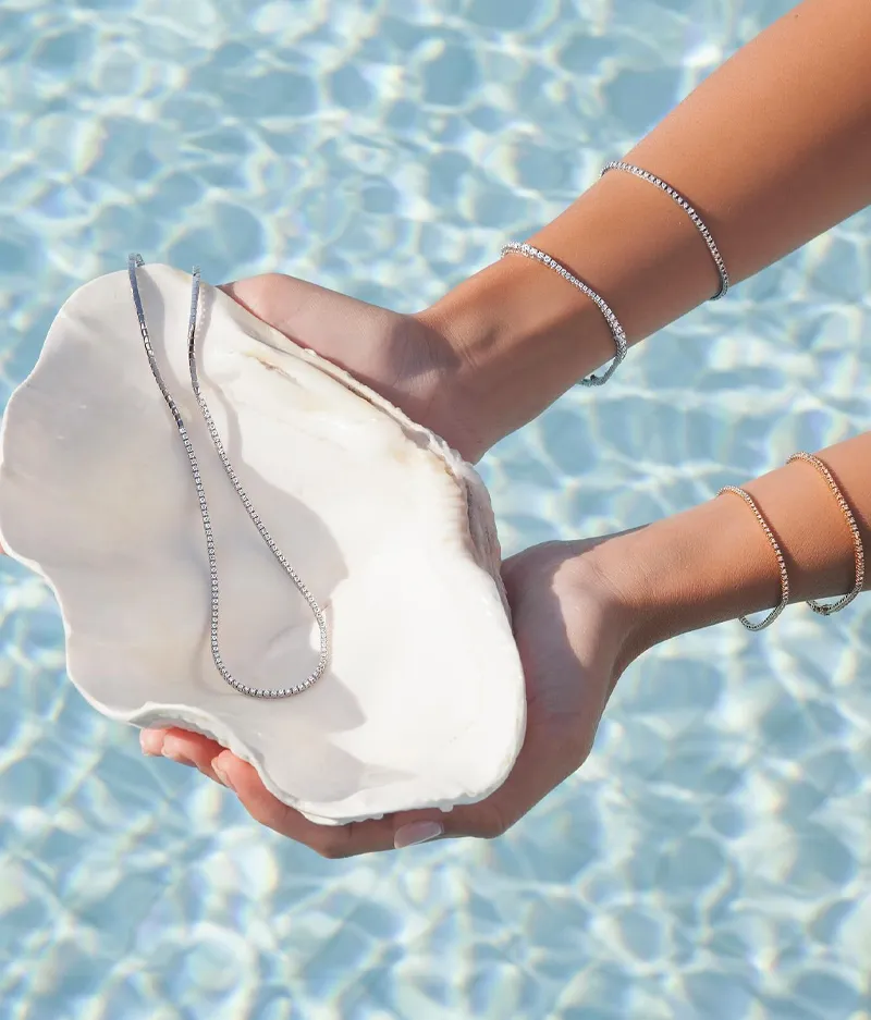 Model holding a shell with jewelry, promoting Futer Bros Jewelers.