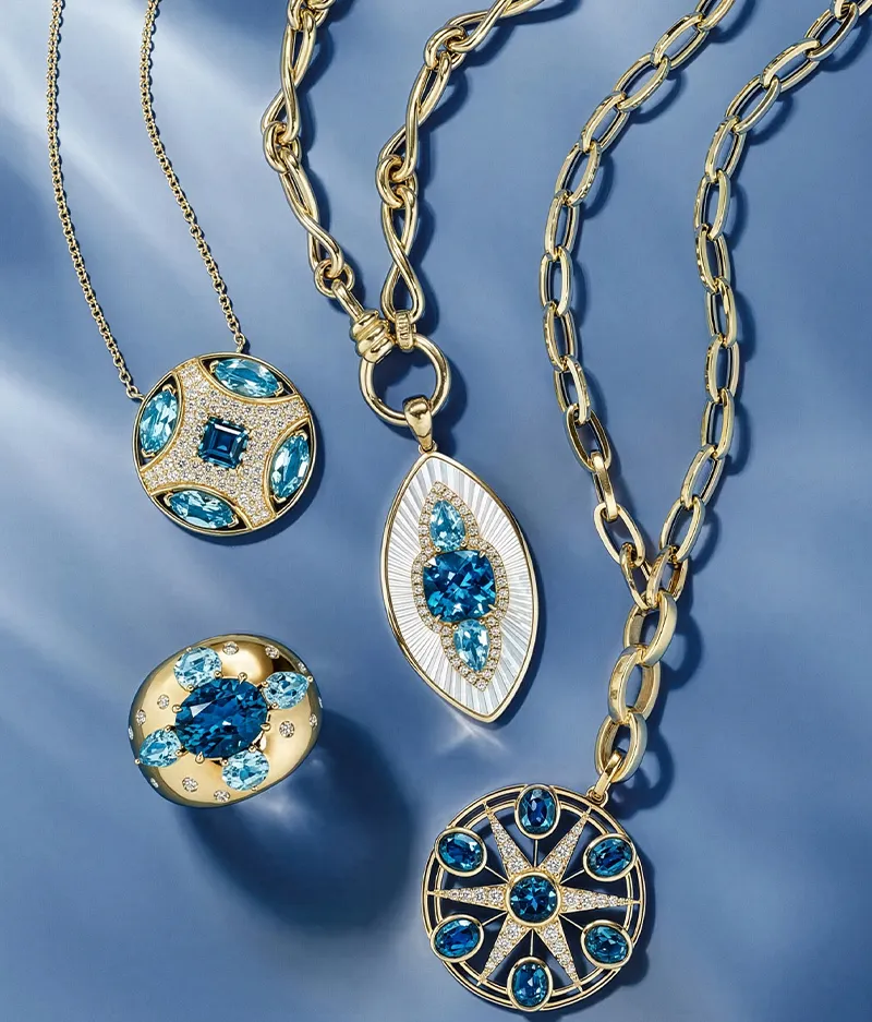 Gold necklaces with blue gemstones on a blue background.