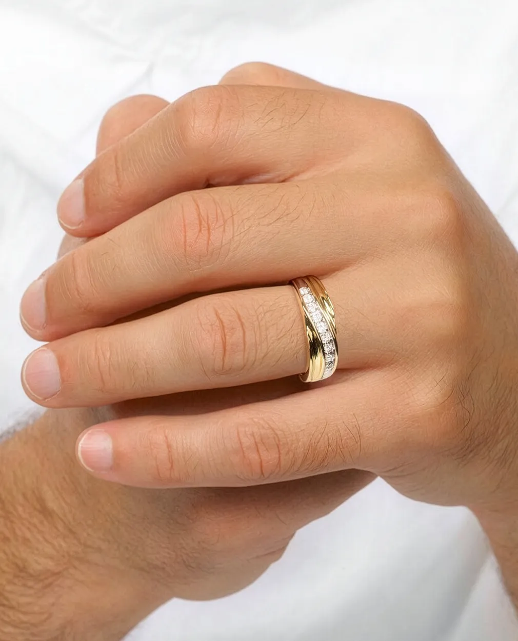 Hands with a gold and diamond wedding band.