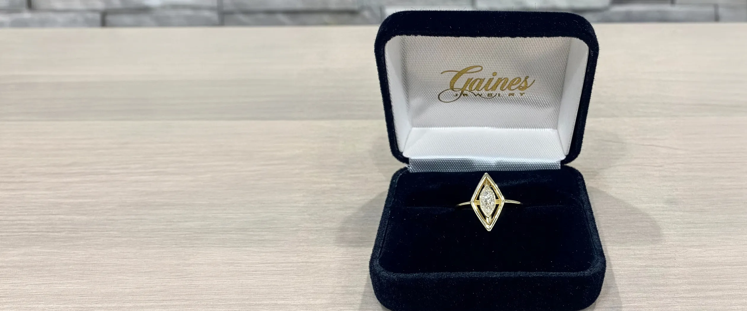 A marquise diamond ring in a black velvet box from Gaines Jewelry.