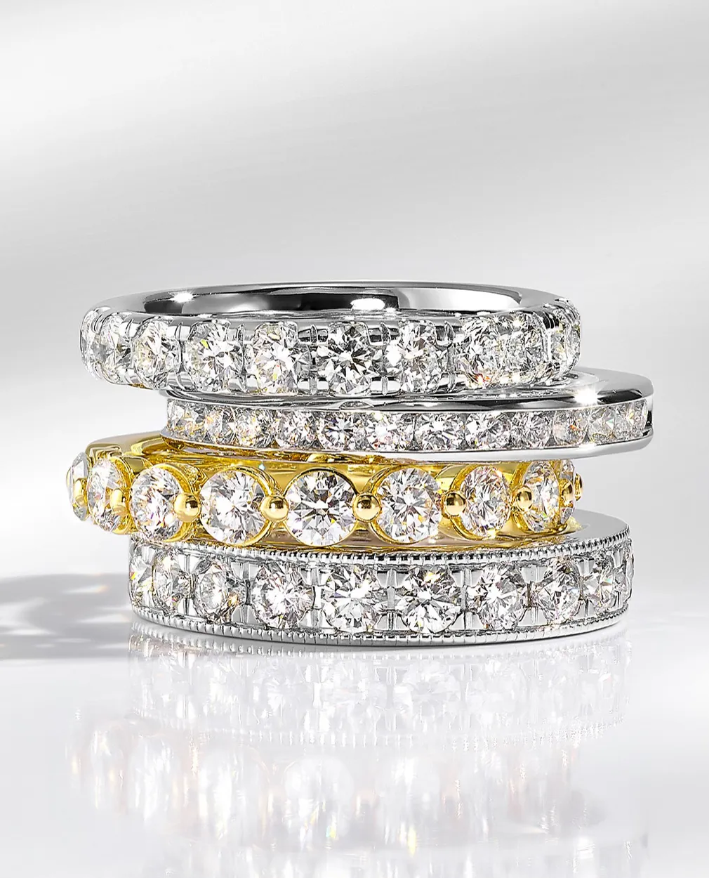 Stacked diamond rings in silver and gold.