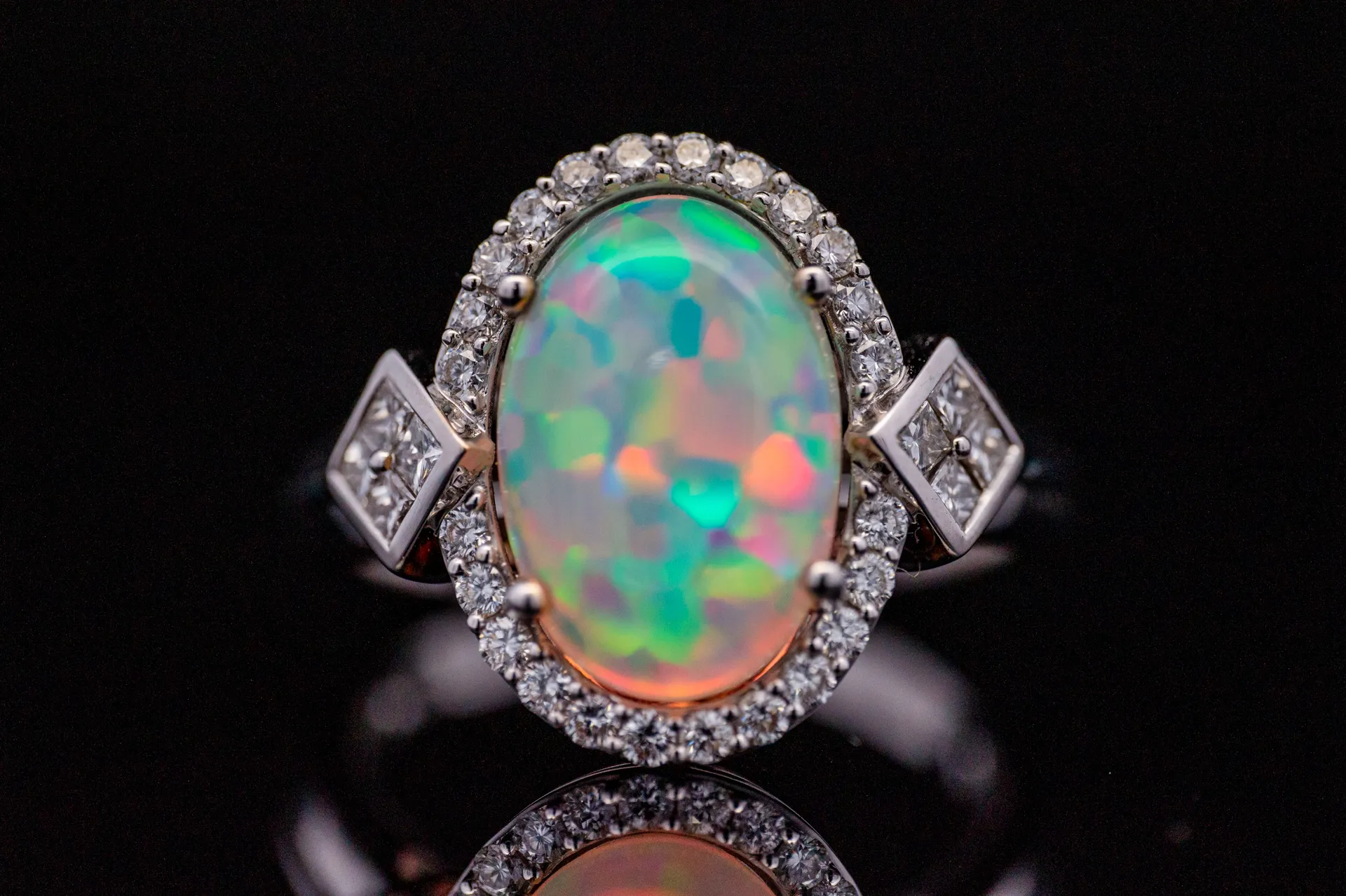 Gold ring featuring a large, colorful opal surrounded by sparkling diamonds.