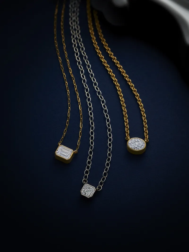 Three elegant necklaces with gold and silver chains, featuring unique gemstone pendants.