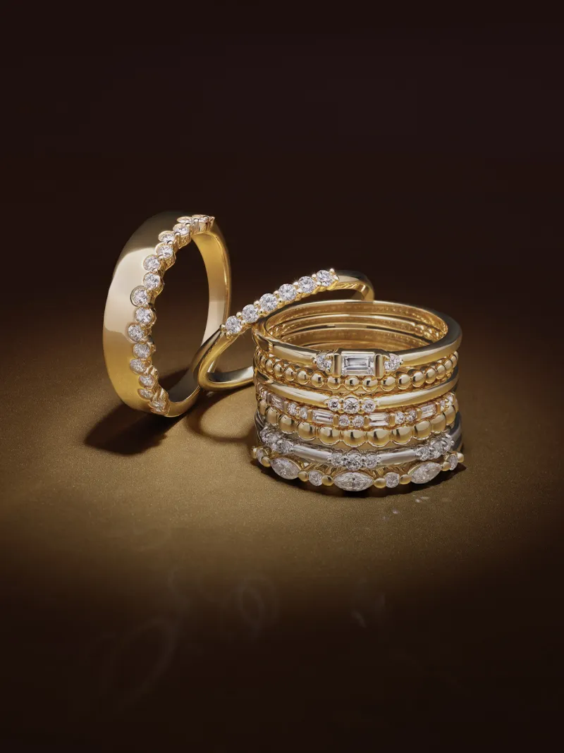 Elegant gold and diamond rings displayed on a dark background.