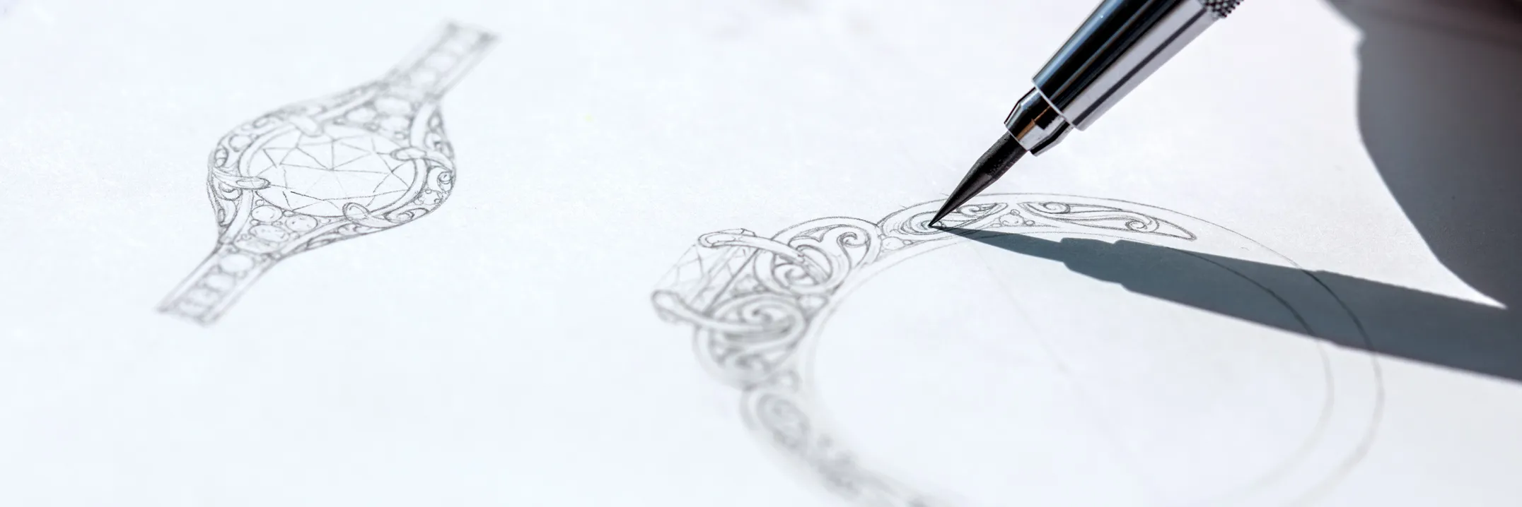 Sketch of an ornate ring design with a pen, showcasing intricate details for custom jewelry.