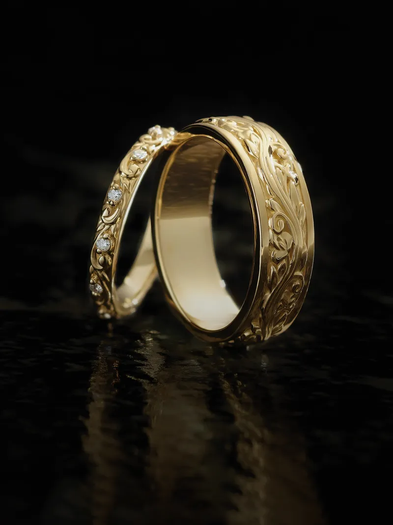 Elegant gold wedding rings with intricate designs and diamonds, reflecting light beautifully.