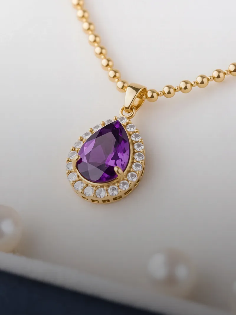 Gold necklace with a purple amethyst pendant surrounded by sparkling stones.