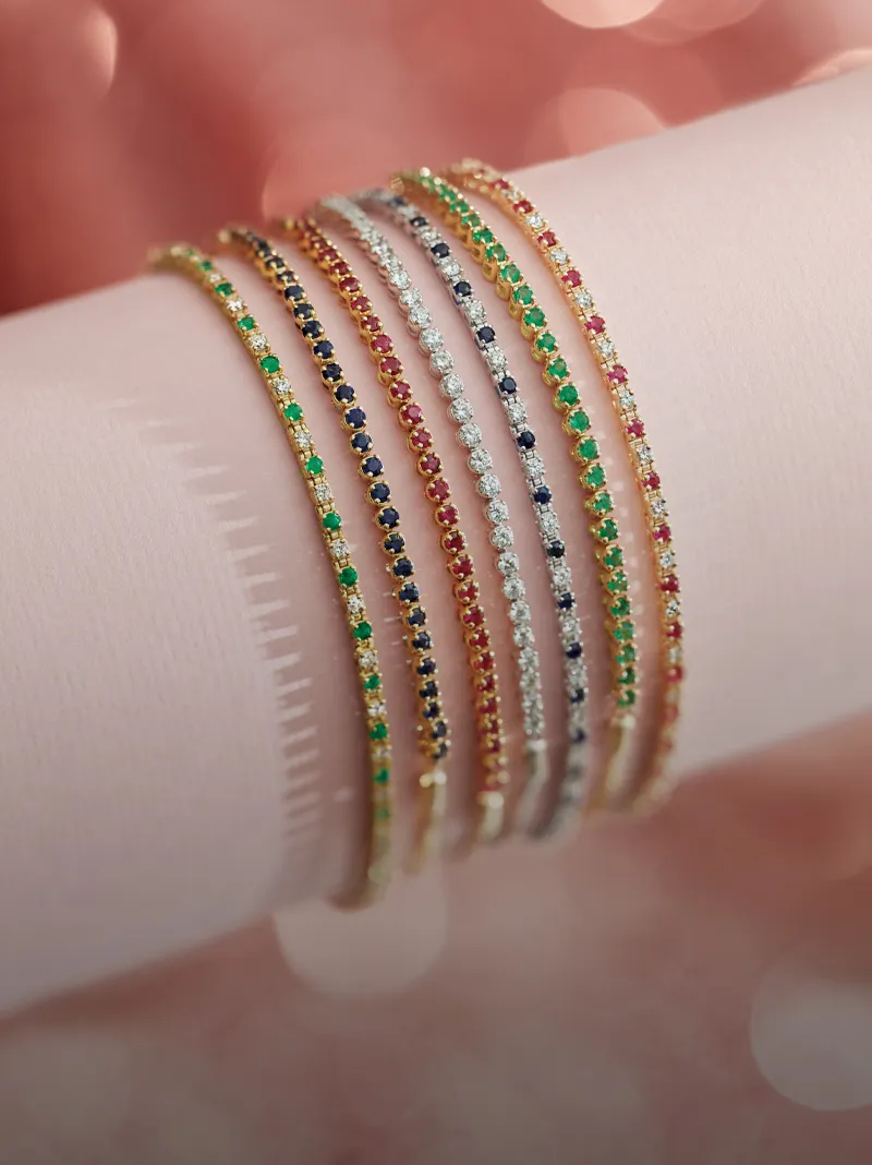 Colorful gemstone bracelets showcased on a pink surface.