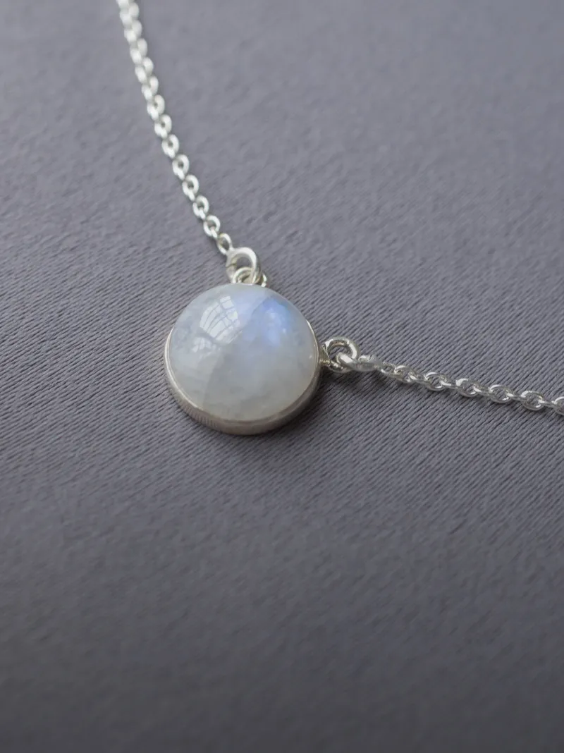 Gold ring with a heart-shaped moonstone, featuring intricate designs, worn on a hand.