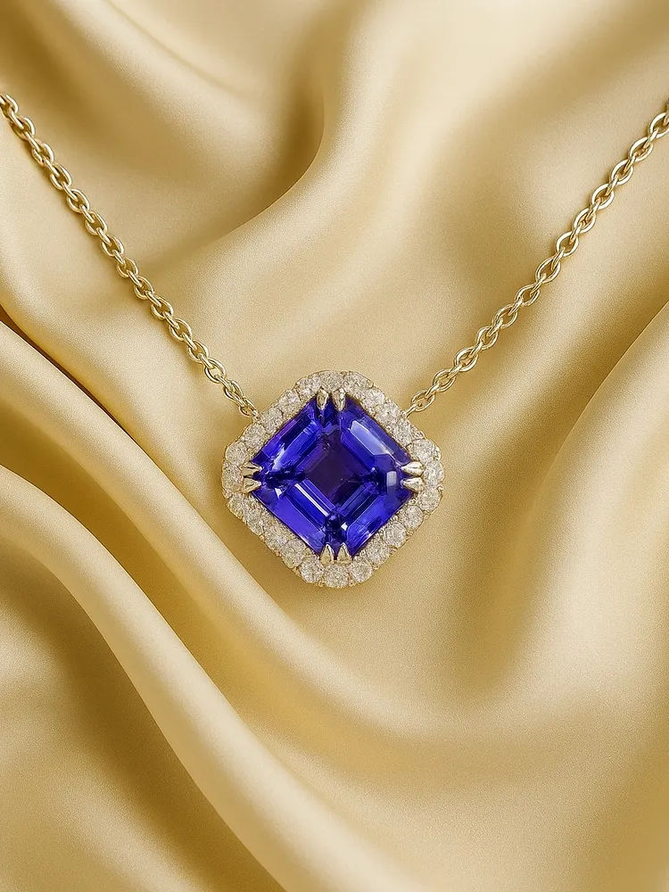 Elegant gold necklace featuring a large purple gemstone surrounded by diamonds, set against a soft golden fabric backdrop.