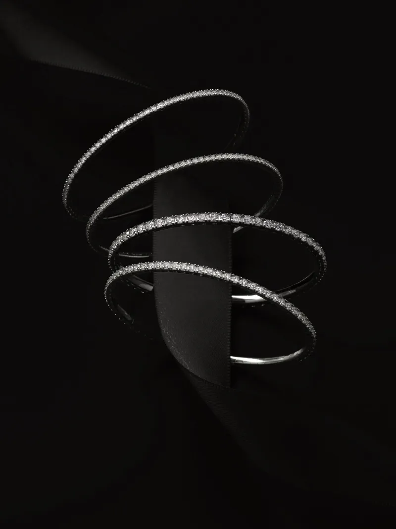 Elegant diamond-studded bracelets displayed against a black background.