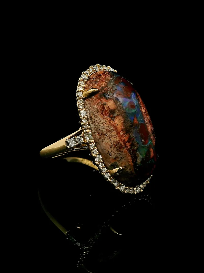 Gold ring featuring a large, colorful opal surrounded by sparkling diamonds.