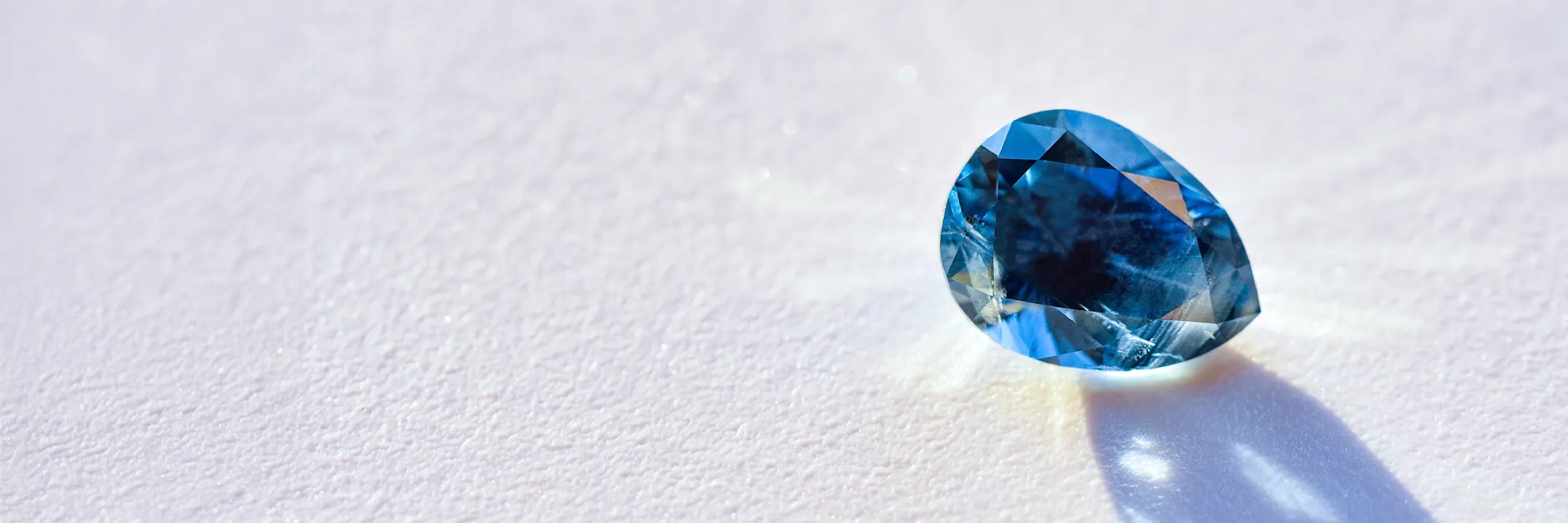 Tanzanite gemstone on a white surface, showcasing its vibrant blue-violet hue.