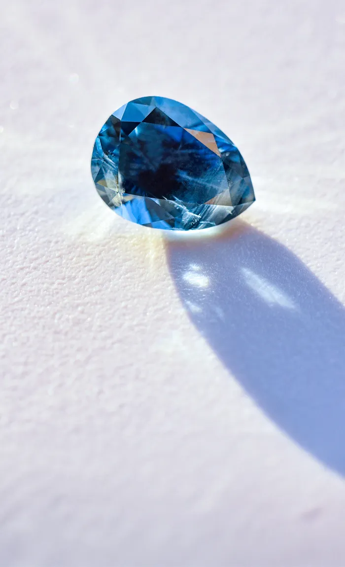 Tanzanite gemstone on a white surface, showcasing its vibrant blue-violet hue.