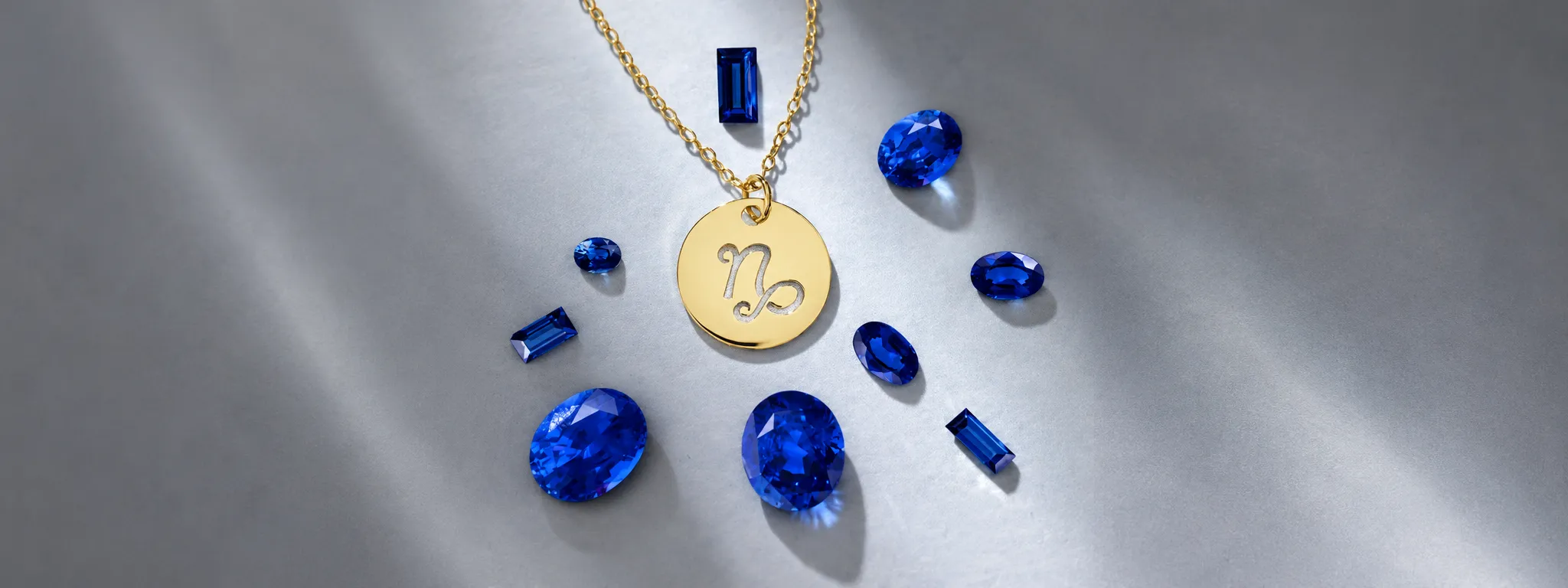Different cuts of sapphires around a gold initials necklace