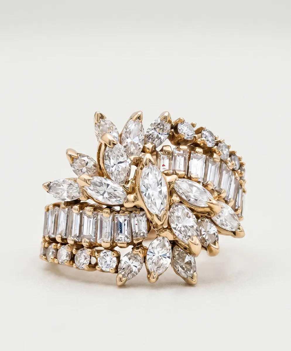 A gold ring with marquise and baguette-cut diamonds in an intricate design.