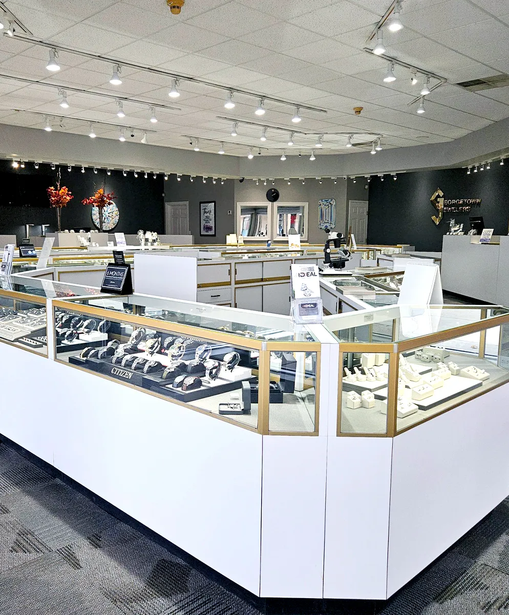 Spacious jewelry store interior with display cases showcasing watches and jewelry under bright lighting.