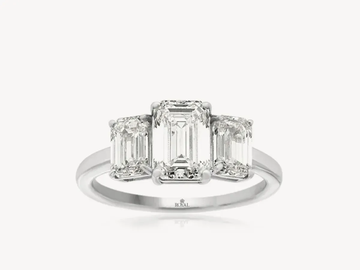 Three-stone emerald-cut diamond ring on a white background. Click to explore lab-grown diamond rings.