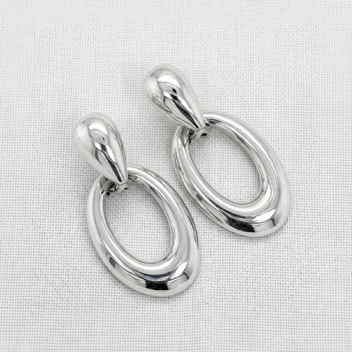 Silver estate earrings on a white background at Georgetown Jewelers.