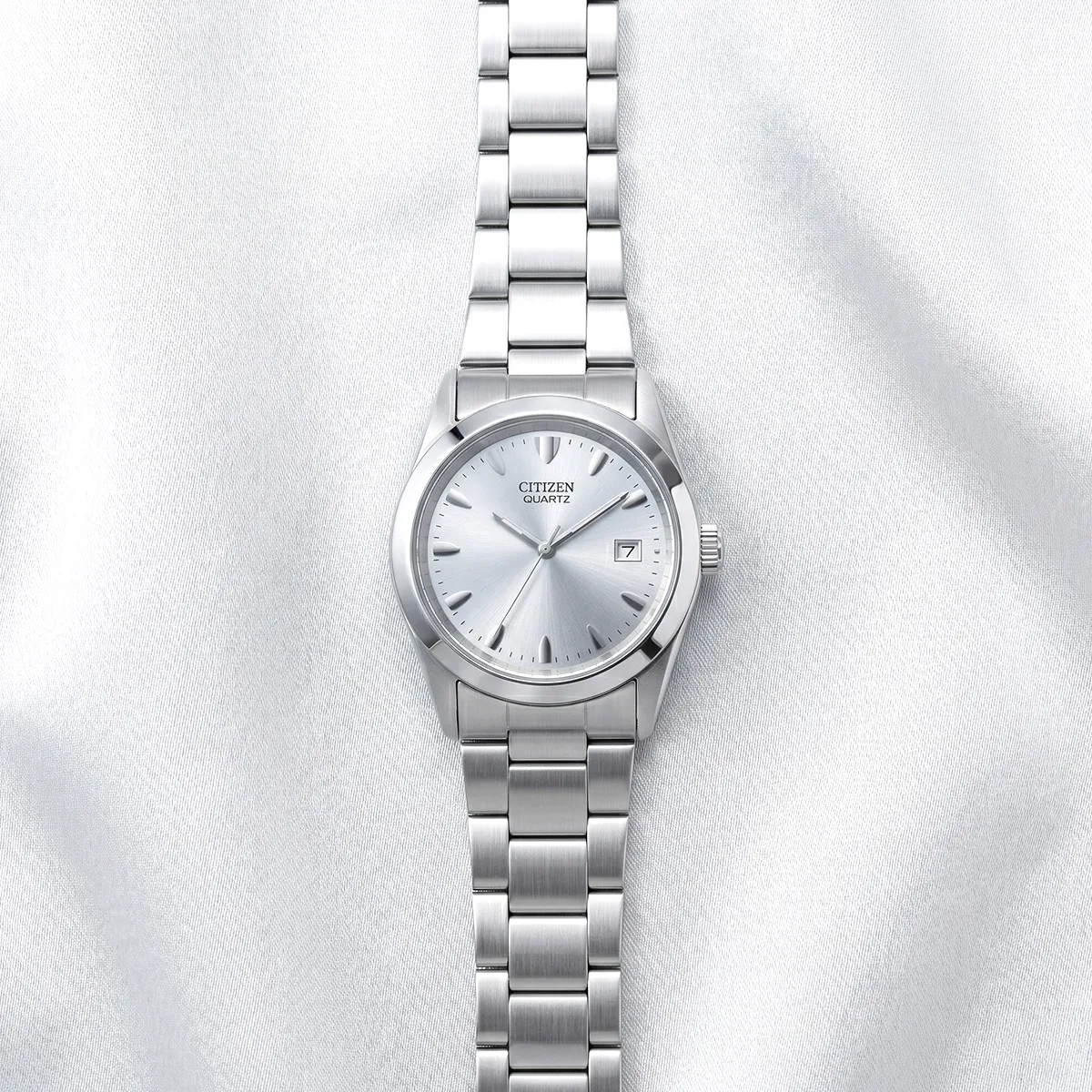 Men's silver Citizen quartz watch with date display on a satin background. Explore men's watches at Georgetown Jewelers.