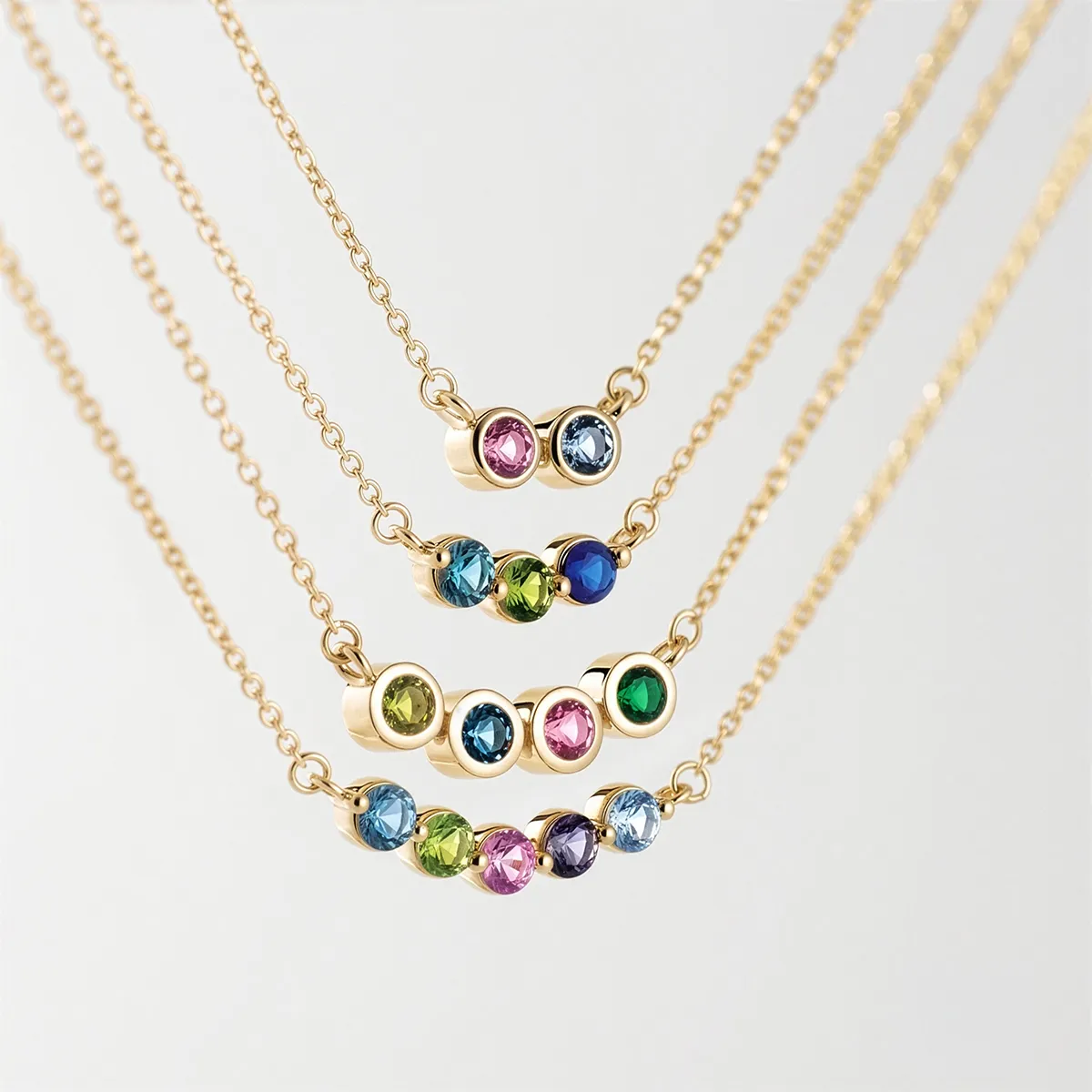 Gold necklaces with colorful gemstones in various arrangements. Explore family jewelry at Georgetown Jewelers.