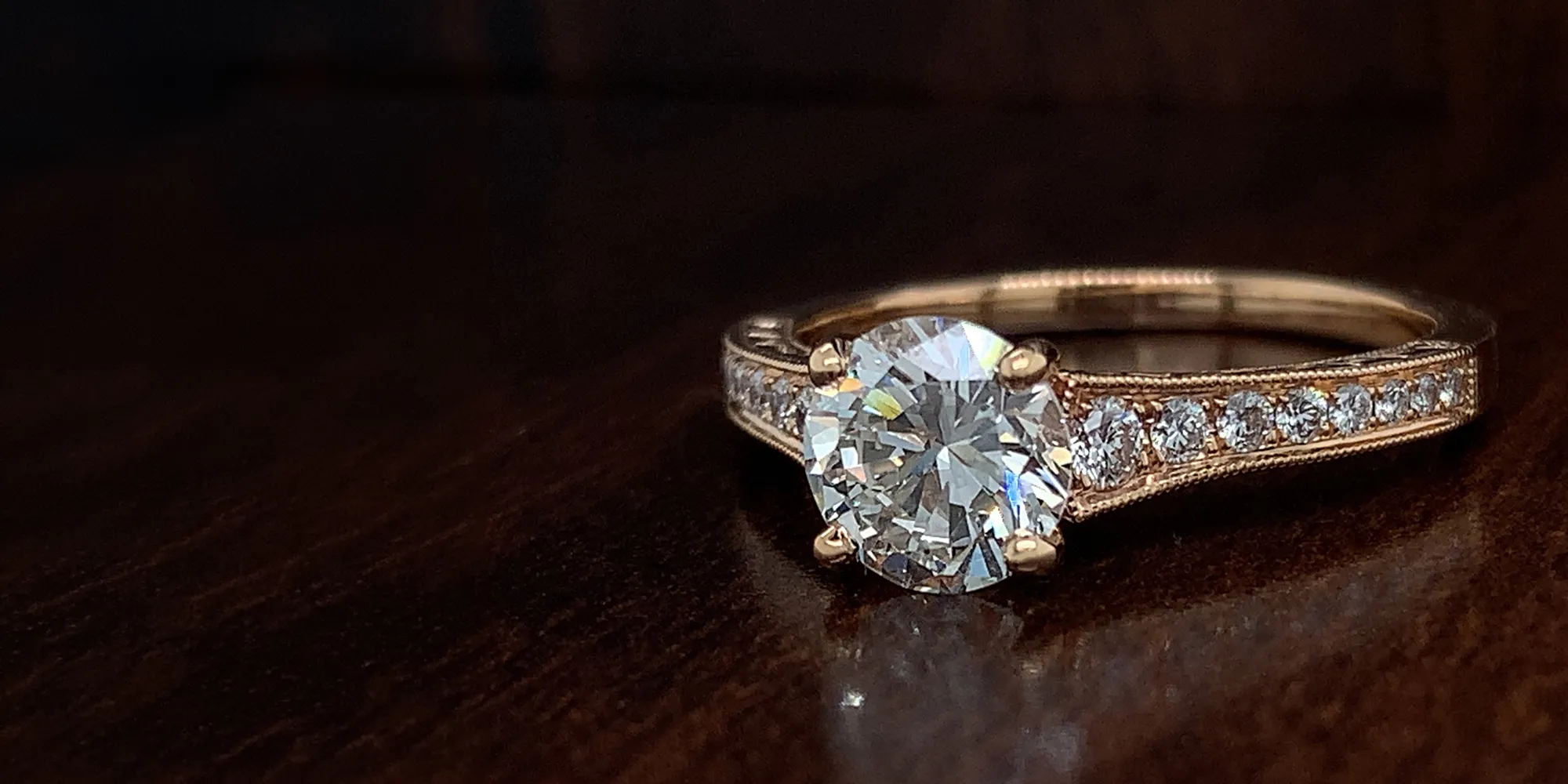 Gold engagement ring with large diamond and smaller diamonds on the band.