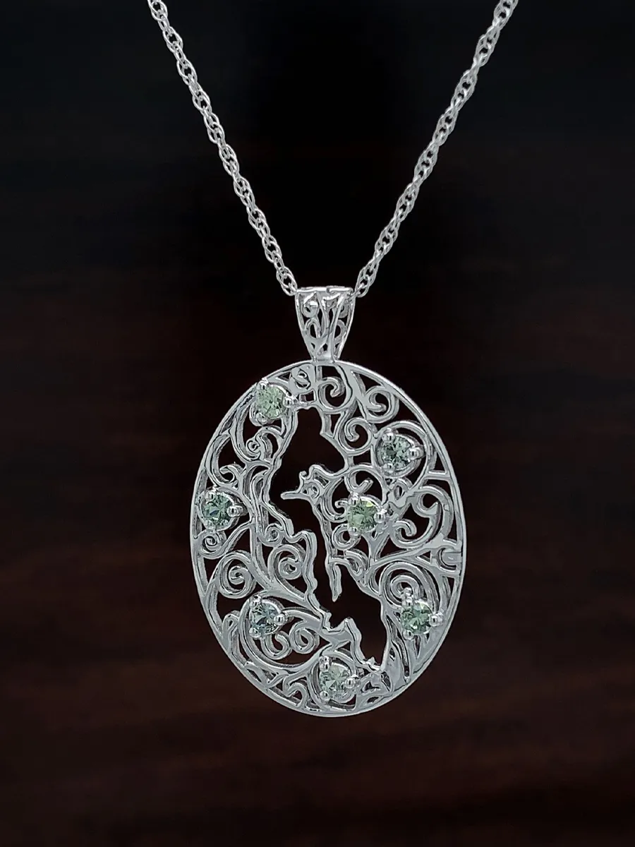 Ornate silver pendant with intricate filigree design and embedded gemstones on a chain.