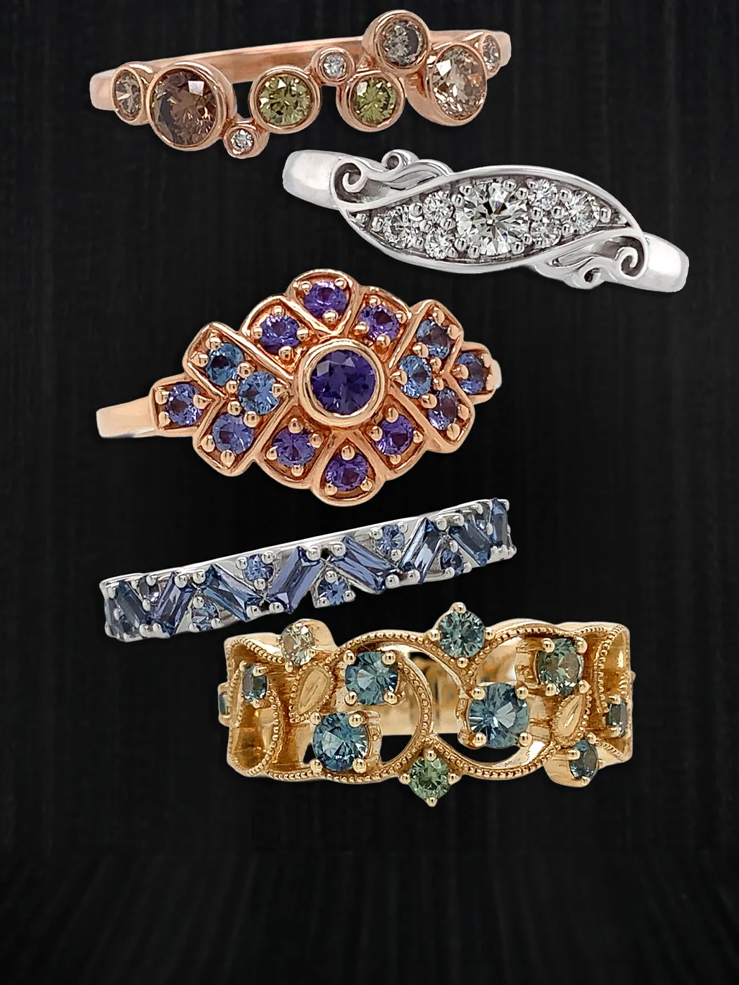 Elegant rings with gemstones and diamonds displayed on black textured background.
