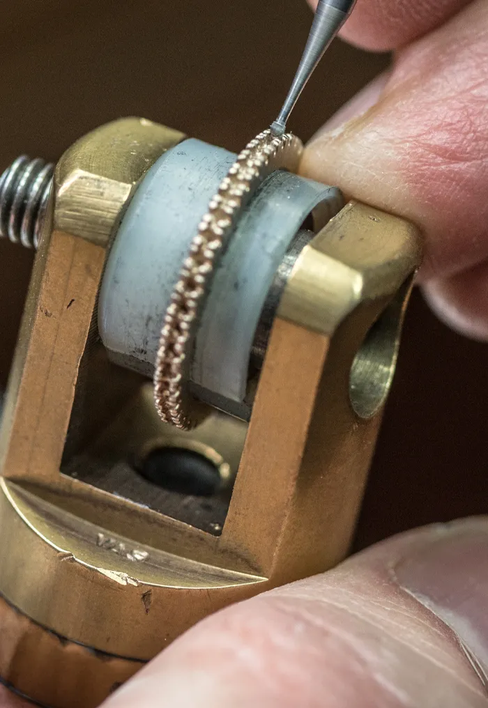 Jeweler working on a ring with precision tool.