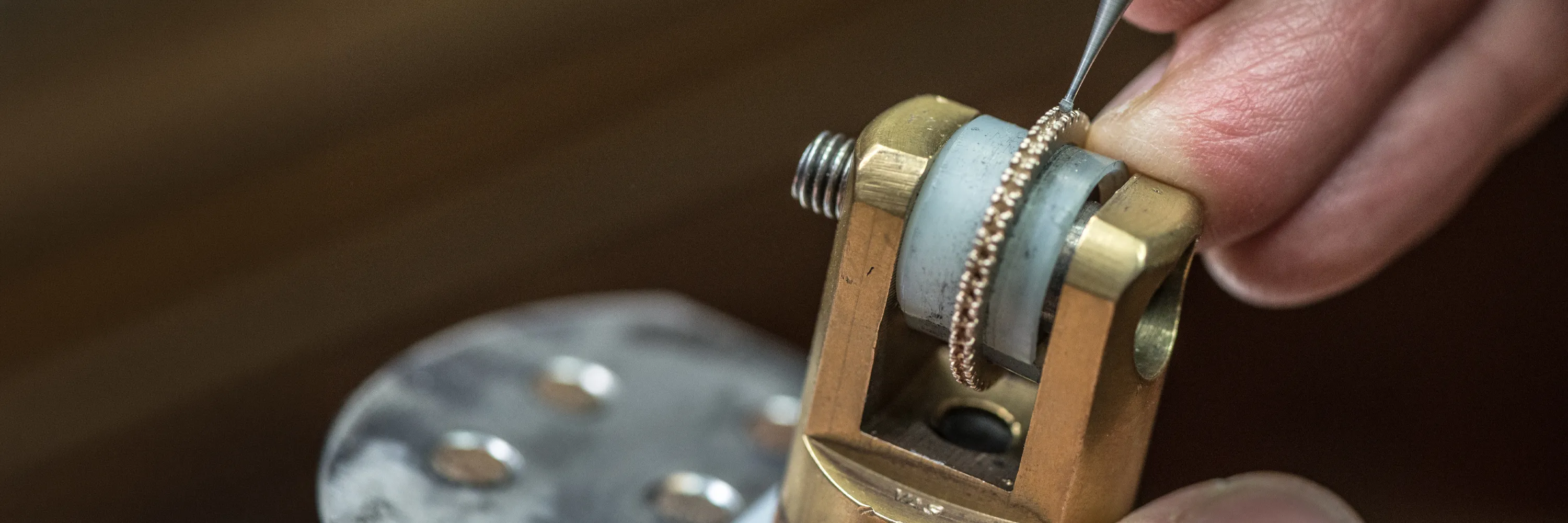 Jeweler working on a ring with precision tool.