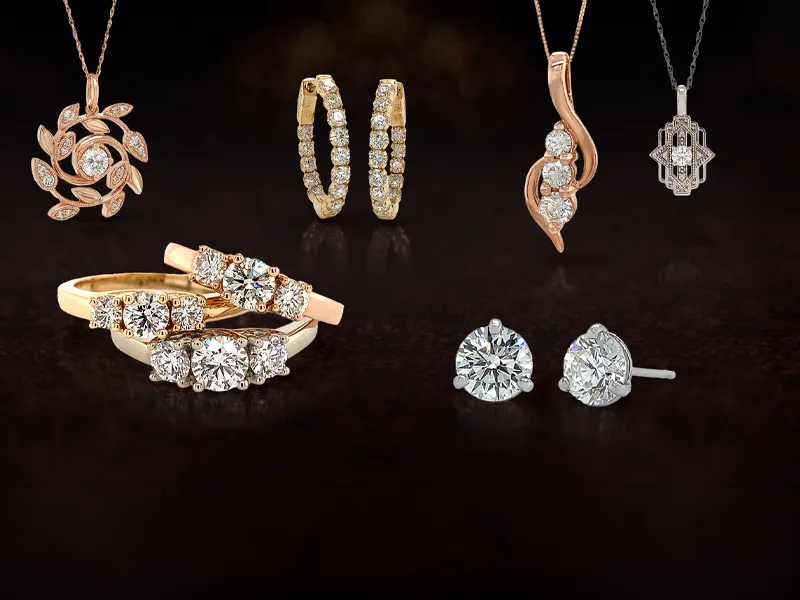A collection of diamond jewelry including rings, earrings, and necklaces on a dark background.