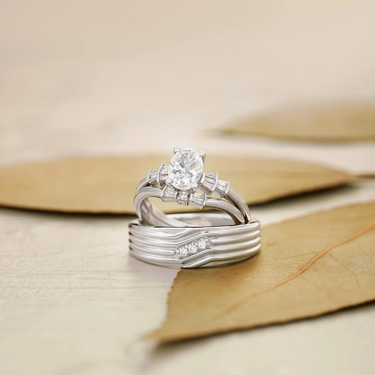Elegant diamond engagement and wedding rings displayed on leaves, showcasing fine jewelry.