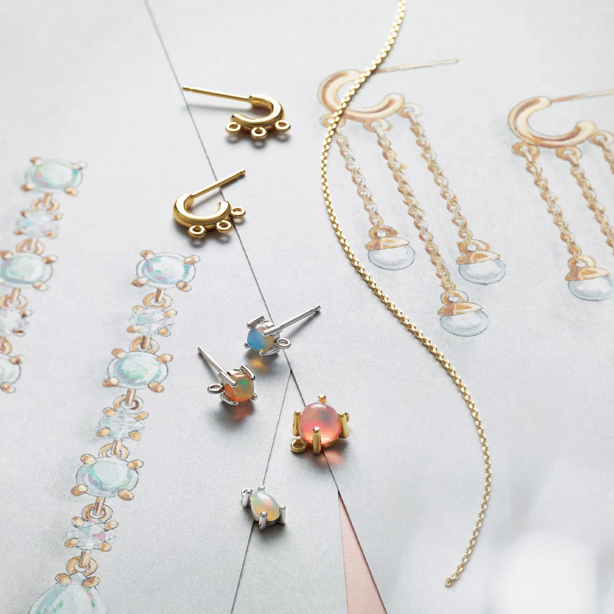 Elegant jewelry pieces including earrings and a chain, displayed alongside design sketches on a soft background.