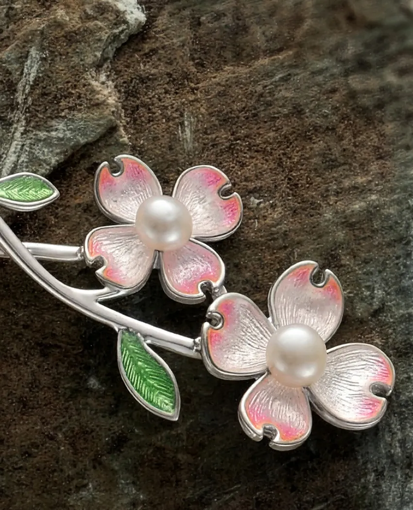 Delicate silver flower brooch with pink enamel and pearl accents.