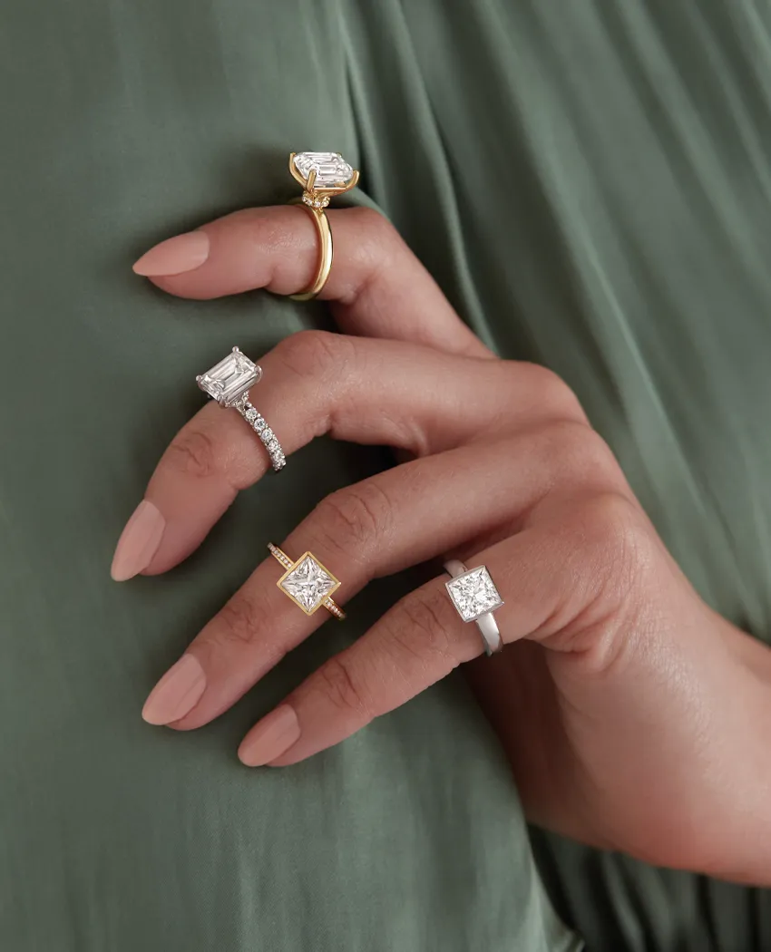 Four elegant rings displayed on a hand, showcasing various diamond styles.