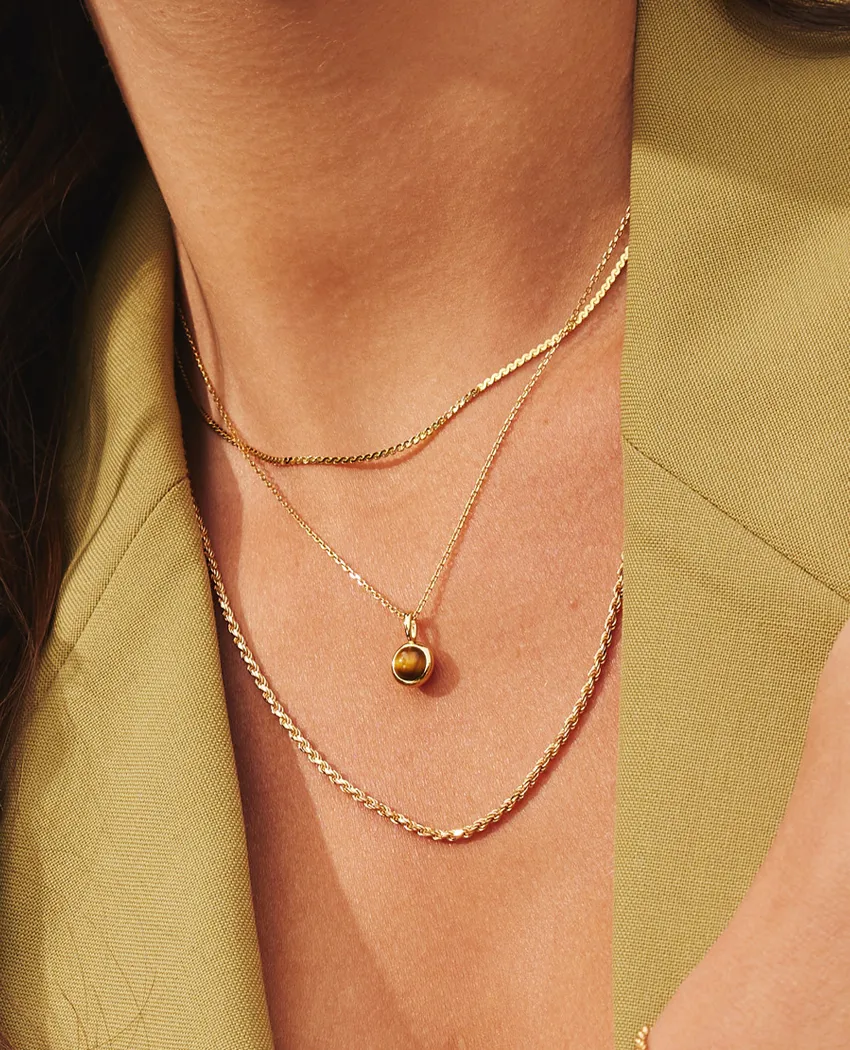 Gold layered necklaces featuring a pendant, perfect for adding elegance to any outfit.