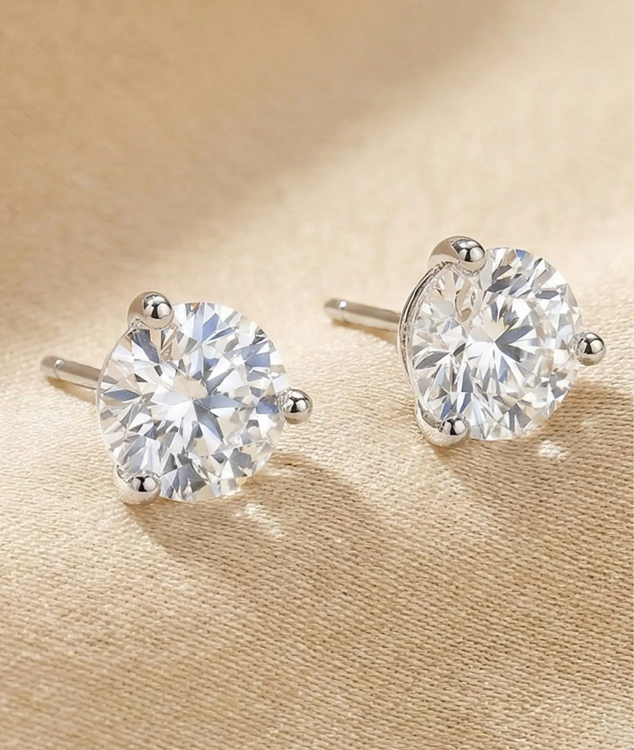 Stud Earrings laying ontop of a tan fabric