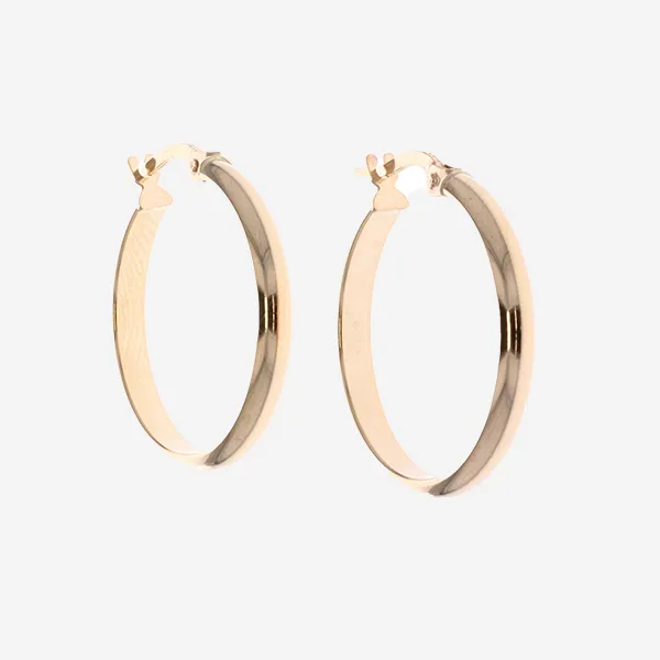 A pair of yellow gold hoop earrings on grey brackgound