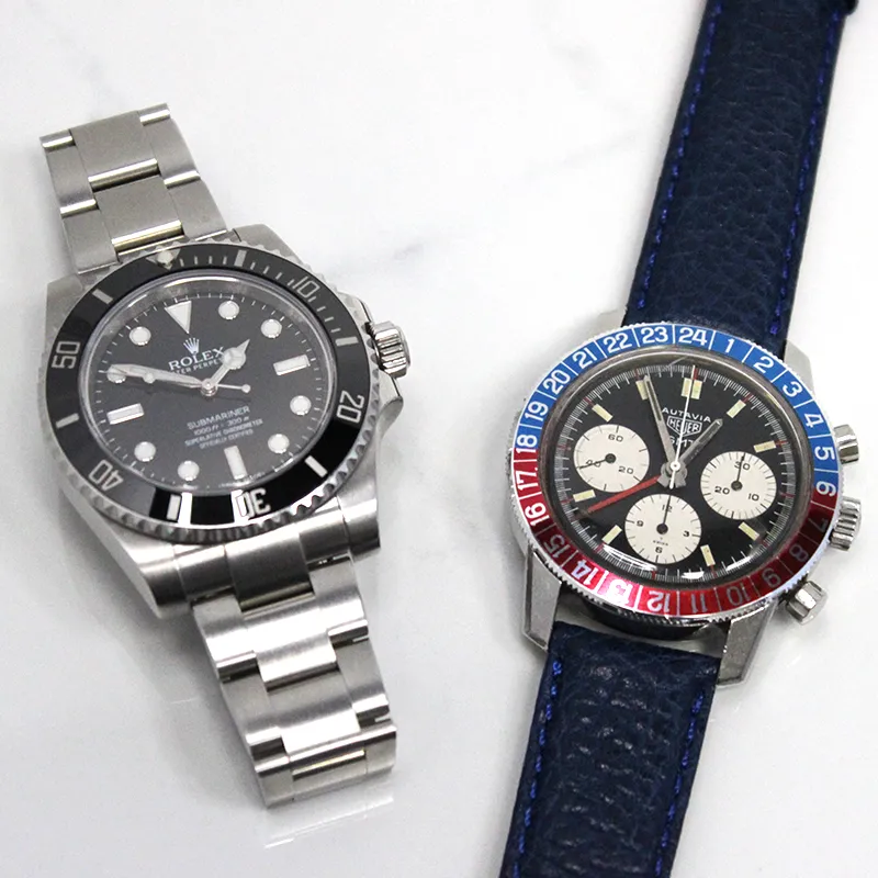 A stainless steel Rolex watch and Heuer Autavia GMT watch with blue leather strap