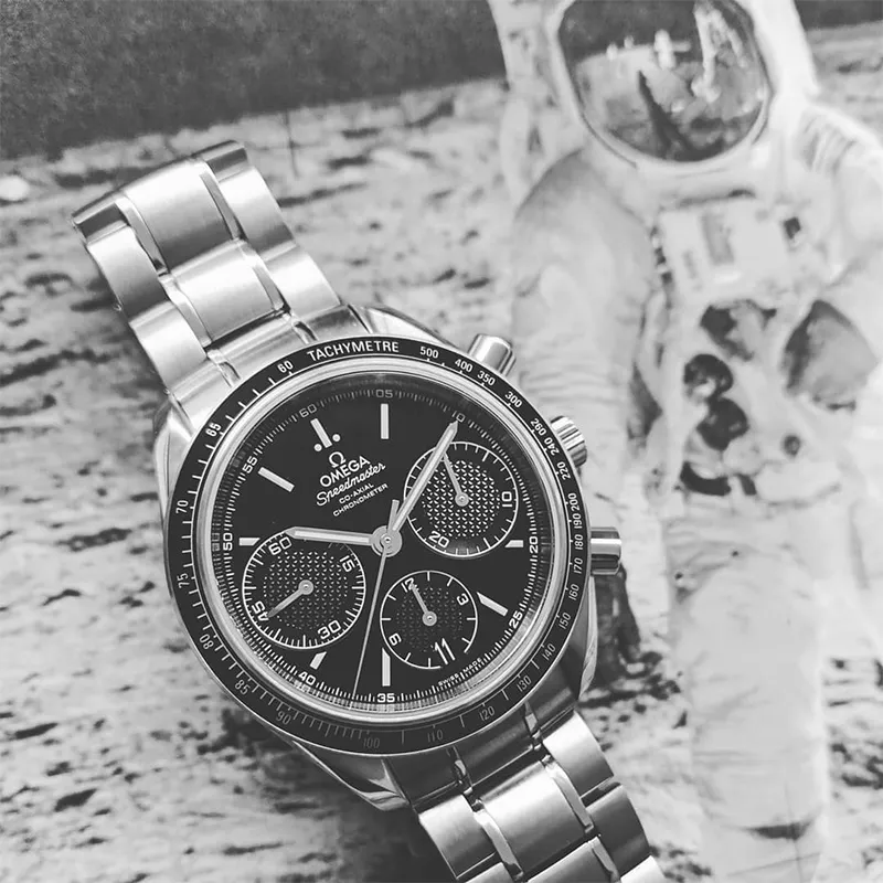 Stainless steel Omega Seedmaster watch with black dial and bezel, sitting on a picture of an astronaut