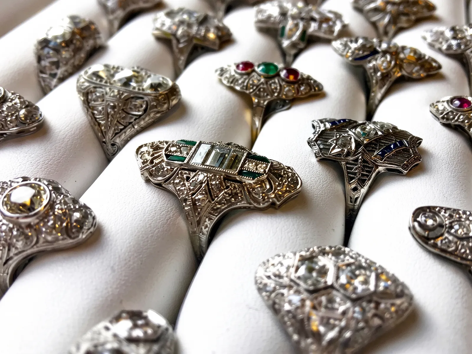 Intricately designed vintage rings with gemstones displayed on a white surface.